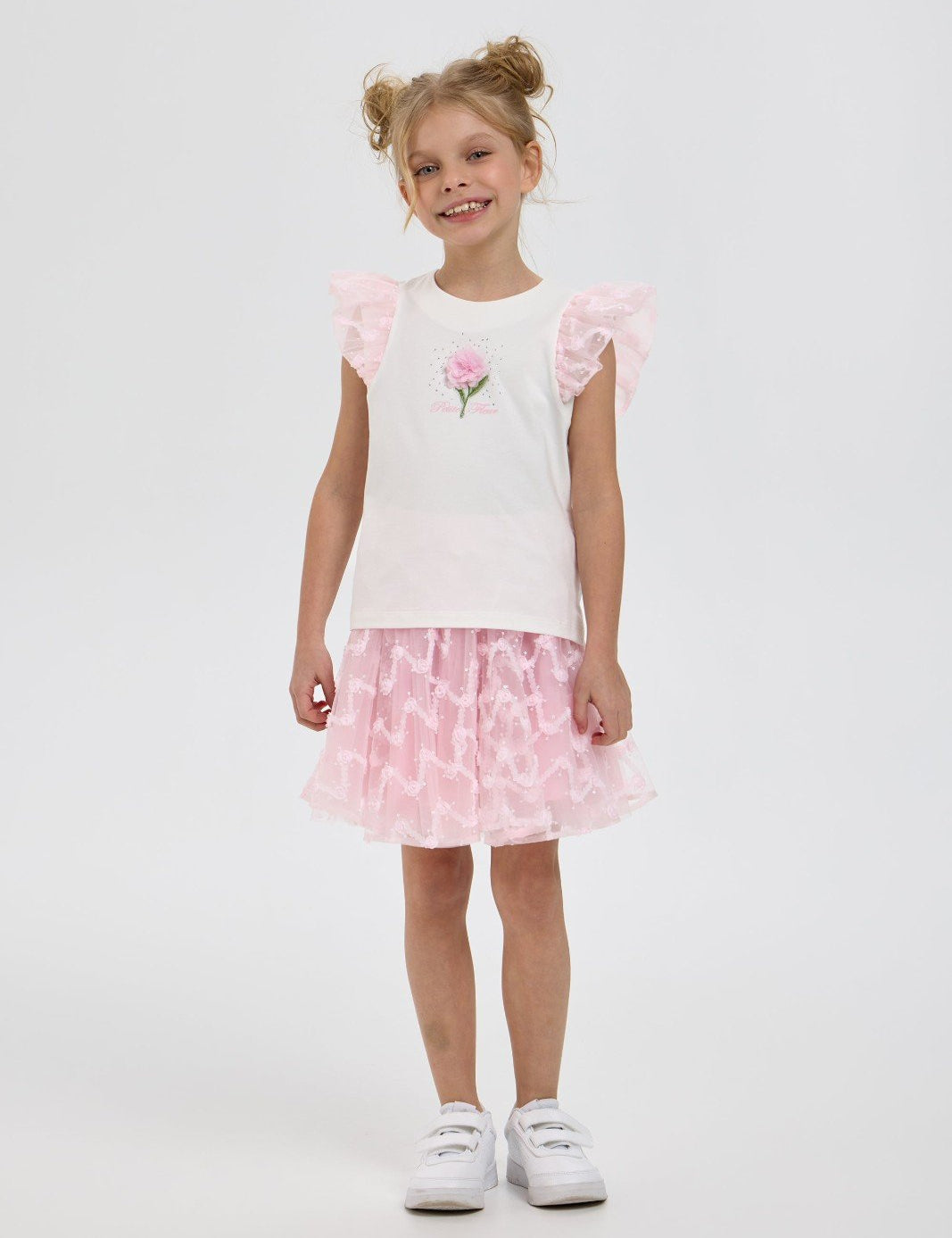 Girl modelling white and pink ruffle top with matching tulle skirt